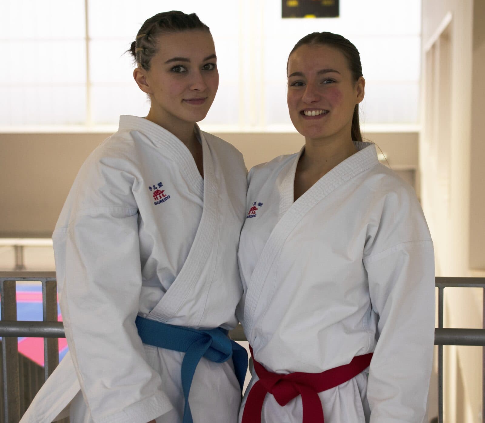 Deux compétitrices du club en karategi, l’une ceinture bleue et l’autre ceinture rouge