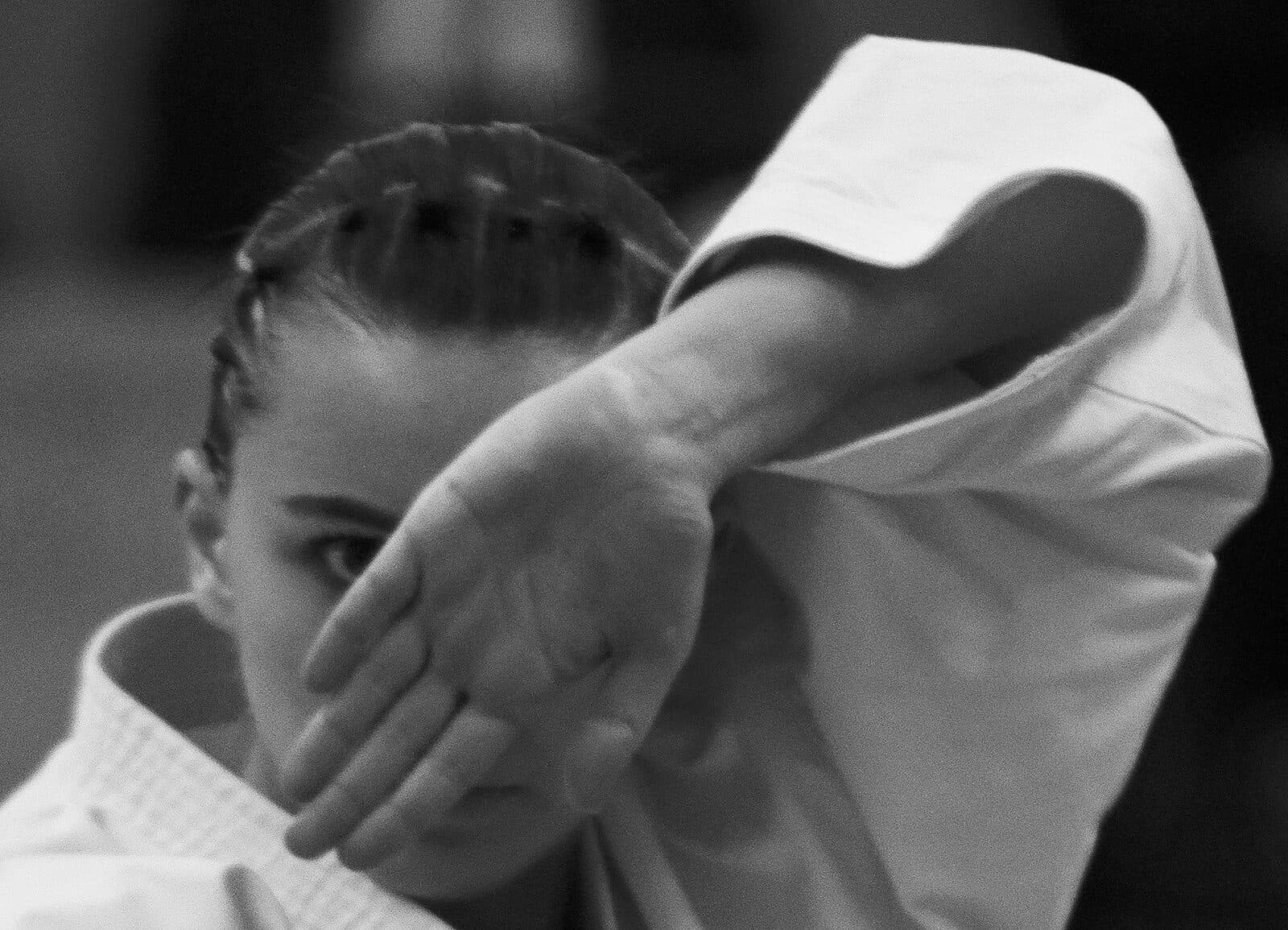 Gros plan en noir et blanc sur le regard et la garde d’une karatéka pendant son kata